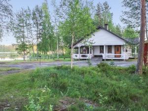 une petite maison blanche au milieu d'un champ dans l'établissement Holiday Home Suvituuli by Interhome, à Pertunmaa