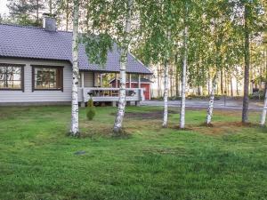 une maison avec un banc dans une cour arborée dans l'établissement Holiday Home Suvituuli by Interhome, à Pertunmaa