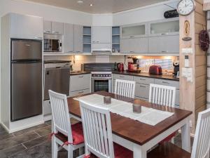 eine Küche mit einem Holztisch und weißen Schränken in der Unterkunft Holiday Home Kesärinne14 by Interhome in Ruka