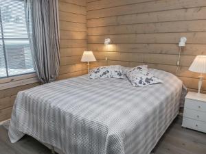 ein Schlafzimmer mit einem Bett mit zwei Kissen und zwei Lampen in der Unterkunft Holiday Home Kesärinne14 by Interhome in Ruka