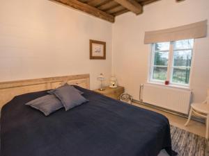 a bedroom with a blue bed and a window at Holiday Home Nybyggningen by Interhome in Björkboda