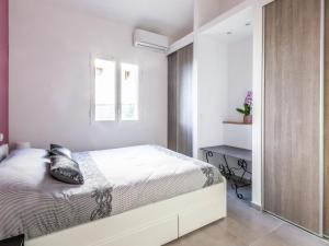 ein weißes Schlafzimmer mit einem Bett und einem Spiegel in der Unterkunft Villa Mont des oiseaux by Interhome in Toulon