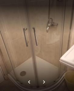 y baño con ducha y puerta de cristal. en Old Trafford Guest House, en Mánchester