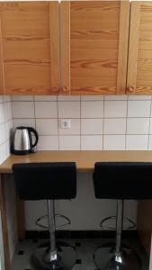 una cocina con 2 taburetes frente a un mostrador en Haus Mena Apartments en Wildemann
