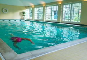 a person swimming in a large swimming pool at Middlethorpe Hall & Spa in York