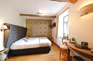 ein Schlafzimmer mit einem Bett und einem Schreibtisch in einem Zimmer in der Unterkunft Hotel Le Saint Hadelin in Celles