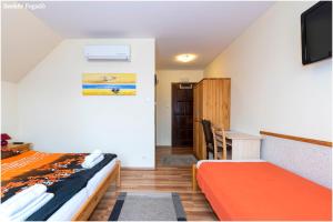 1 dormitorio con 1 cama, escritorio y TV en Szekér Fogadó en Bátonyterenye
