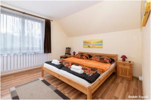 a bedroom with a bed and a large window at Szekér Fogadó in Bátonyterenye