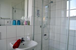 Oberhof的住宿－Hotel "Cafe Verkehrt" - Wellcome Motorbiker, Berufsleute und Reisende im Schwarzwald，白色的浴室设有水槽和淋浴。