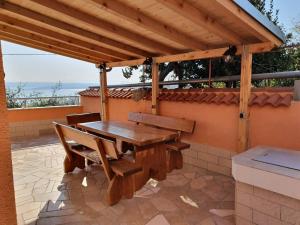 a wooden table and chairs under a wooden pergola at Dramalj 17 Apartments in Dramalj