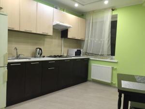 チェルカースィにあるApartment on Khreshchatyk 200 centerのキッチン(黒いキャビネット、シンク、電子レンジ付)