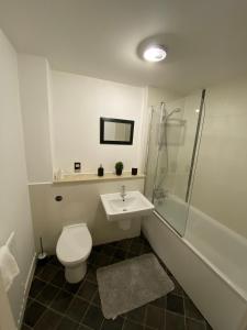 a bathroom with a toilet and a shower and a sink at Tailor That Property - Chelsea House in Milton Keynes