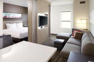 a hotel room with two beds and a television at HYATT House Pittsburgh-South Side in Pittsburgh