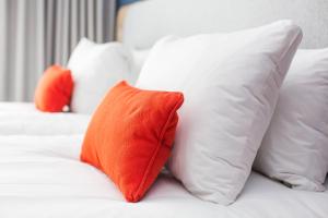 a group of white pillows on a bed at Holiday Inn Express Amsterdam - North Riverside by IHG in Amsterdam