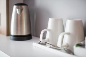 two coffee cups sitting on a counter next to a thermos at Holiday Inn Express Amsterdam - North Riverside by IHG in Amsterdam