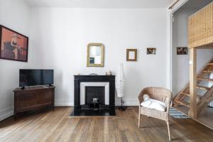 a living room with a tv and a fireplace at Le Denfert, 40m2 avec vue in Grenoble