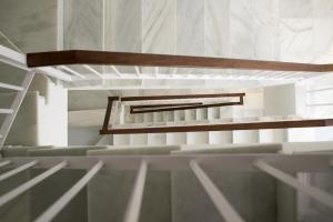 an empty room with white walls and wooden stairs at La Posada del Mercado in Cádiz