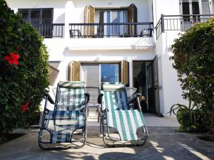 two lawn chairs sitting in front of a house at Tedy's Townhouse-Margarita Gardens in Paphos City