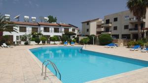a swimming pool in front of a building at Tedy's Townhouse-Margarita Gardens in Paphos City