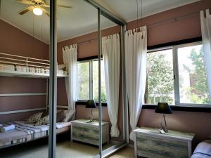a bedroom with two bunk beds and a mirror at Tedy's Townhouse-Margarita Gardens in Paphos City +20 photos