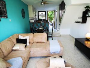 Tedy's Townhouse-Margarita Gardens في بافوس: غرفة معيشة مع أريكة بنية والجدران الزرقاء