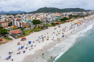 uma vista aérea de uma praia com pessoas e guarda-sóis em Hotel Vila Mar em Florianópolis