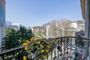 a balcony with a bunch of flowers on a railing at Le Denfert, 40m2 avec vue in Grenoble