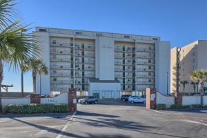 a large building with cars parked in a parking lot at Lei Lani Tower by Meyer Vacation Rentals in Orange Beach
