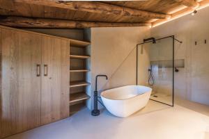 a bathroom with a tub and a glass shower at La Baumeta in San Mauricio +46 photos