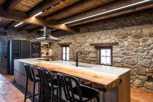 a kitchen with a counter with a island in a stone wall at La Baumeta in San Mauricio