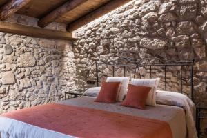 a bedroom with a bed in a stone wall at La Baumeta in San Mauricio