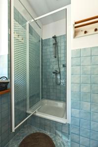 a blue tiled bathroom with a tub and a shower at Apartament Kaskada & Spa in Zakopane