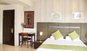 a bedroom with a bed and a table with a chair at National Hotel - Jerusalem in Jerusalem