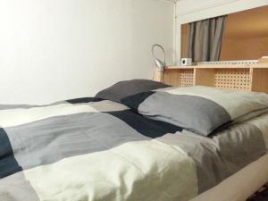 a bed with a blanket on it in a room at Le Denfert, 40m2 avec vue in Grenoble