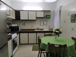 a kitchen with a table with a vase of flowers on it at University Area Msida in Msida