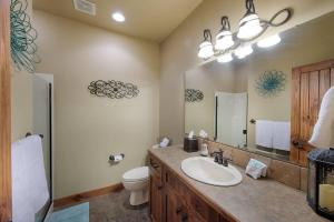 a bathroom with a sink and a toilet and a mirror at Greystone on Payette Lake by Casago McCall - Donerightmanagement in McCall +17 photos