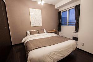 a bedroom with a large bed and a window at Sun Court North 7 Ichibankan / Vacation STAY 7374 in Sapporo