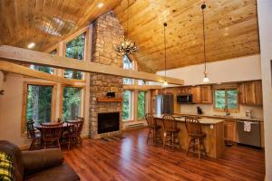 a kitchen and living room with a stone fireplace at Carlson Cabin by Casago McCall - Donerightmanagement in McCall