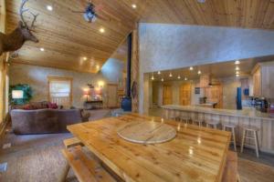 ein Wohnzimmer mit einem Holztisch und einer Küche in der Unterkunft Cascade Multi-Family Cabin by Casago McCall - Donerightmanagement in Cascade