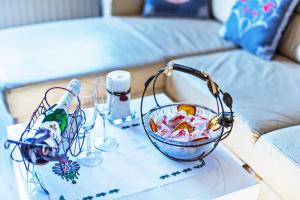 a table with a bowl and glasses on a couch at Apartament Kaskada & Spa in Zakopane