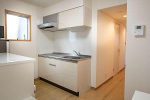 a kitchen with white cabinets and a sink at Noah Ikebukuro / Vacation STAY 7325 in Tokyo