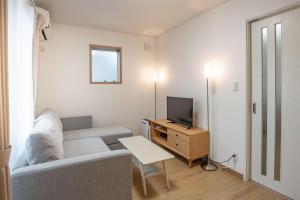 een woonkamer met een bank en een tv bij Noah Ikebukuro / Vacation STAY 7325 in Tokyo