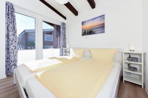 ベンサージールにあるFerienwohnung Sommerwindの白いベッドルーム(ベッド1台、窓付)