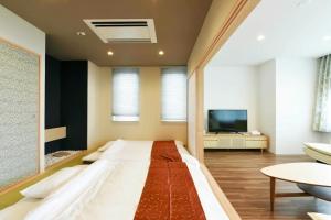 un grande letto in una camera con TV di Ryoan / Vacation STAY 80269 a Otaru