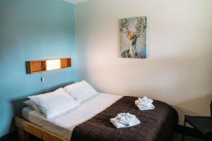 1 dormitorio con 1 cama con 2 toallas en HI Lake Louise Alpine Centre - Hostel, en Lago Louise