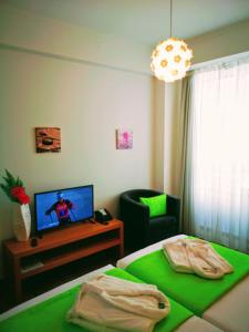 a bedroom with a bed and a chair and a television at Casa dos Avós Apartments in Funchal