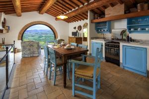 a kitchen with a wooden table and blue chairs at Le Filigare Winery & Accomodation in Chianti in San Donato in Poggio