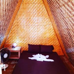 um quarto com uma cama e uma parede de madeira em SHUKRAN Apartelle em Siquijor