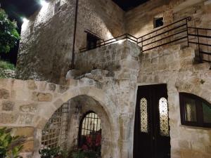 un antiguo edificio de piedra con una puerta y ventanas negras en Porolithos Boutique Hotel en Rodas