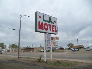una señal de motel en medio de un estacionamiento en LA Motel, en Claude